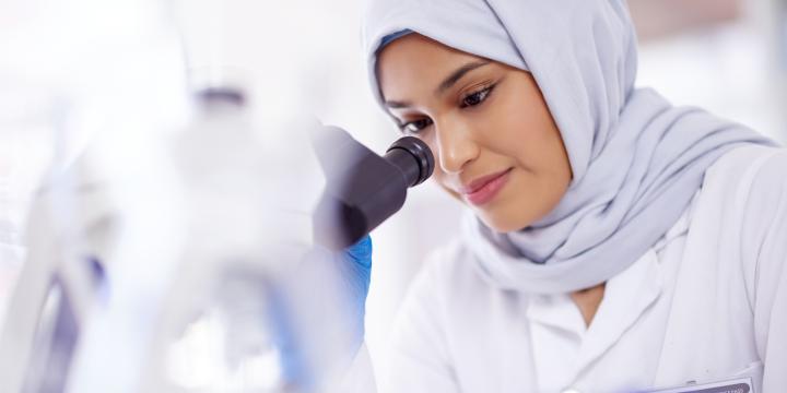Vrouw met hoofddoek microscoop